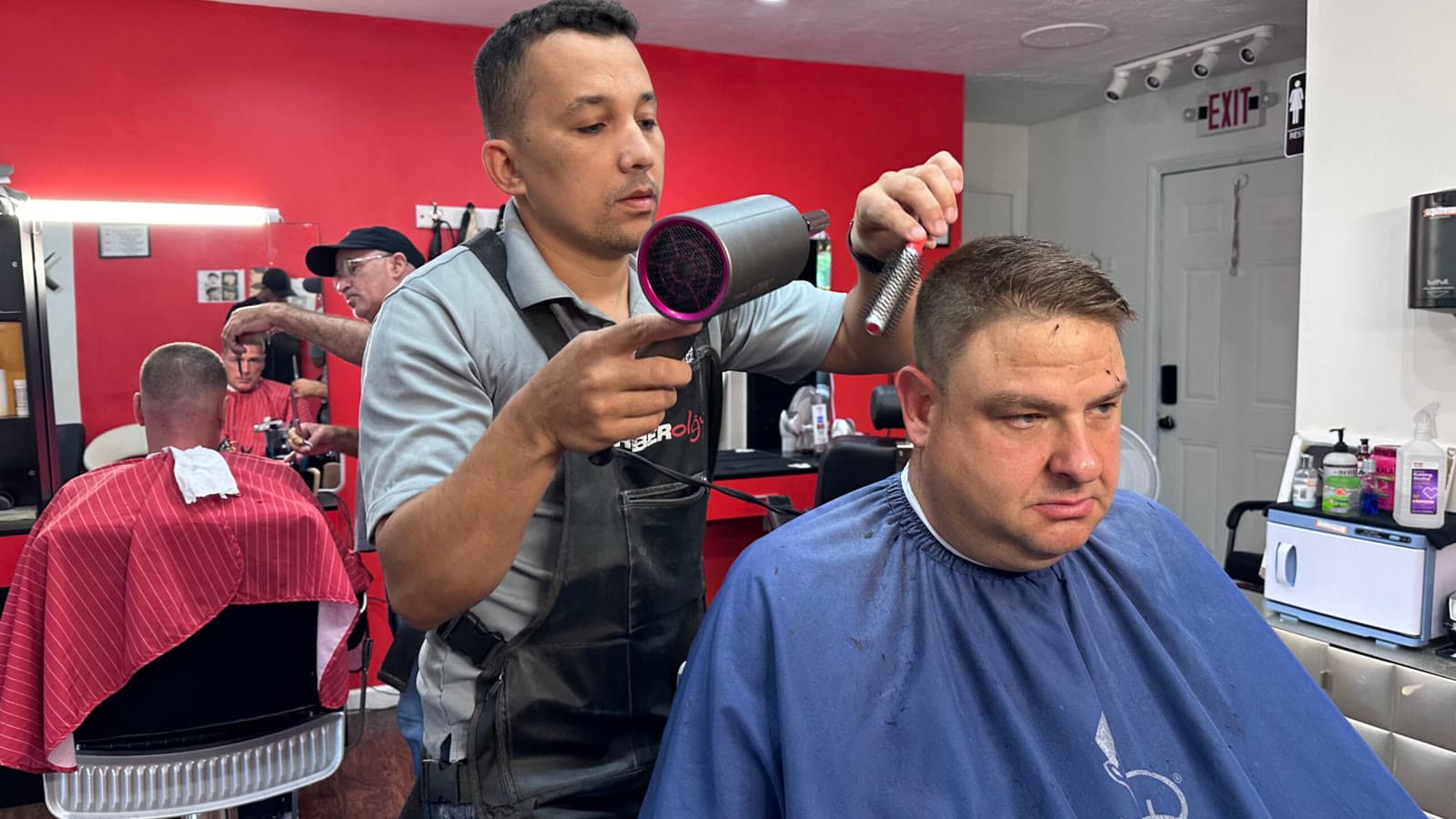 Barber finishing a cut at Flavio's